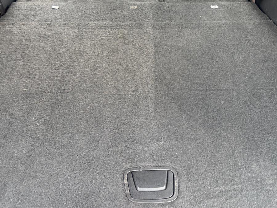 Cargo carpet halfway through vacuuming, with a clear line between the cleaned and uncleaned sides