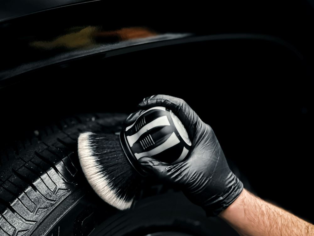 Stock photo: gloved hand dressing a tire